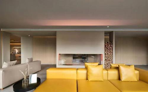a living room with a yellow couch and a fireplace at Ebo Hotel in Hangzhou