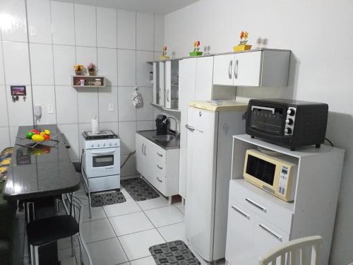 małą kuchnię z kuchenką mikrofalową na lodówce w obiekcie Apartamento no Mar Grosso em Laguna SC. w mieście Laguna