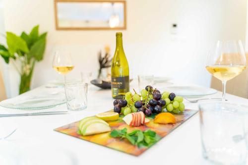 a plate of fruit and a bottle of wine on a table at Art Apartment In Mamila - King David Residence in Jerusalem