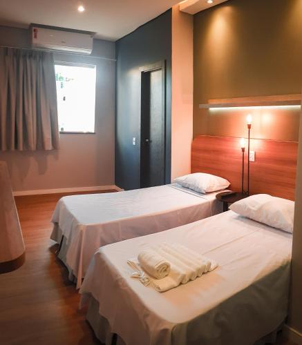 a hotel room with two beds with towels on them at Blue Inn Hotel in Boa Vista