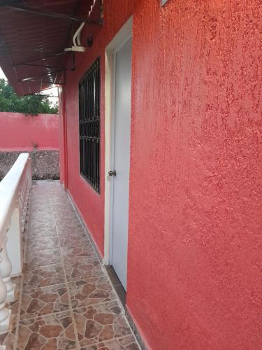 a red building with a white door and a red wall at Villa lirios in Valladolid
