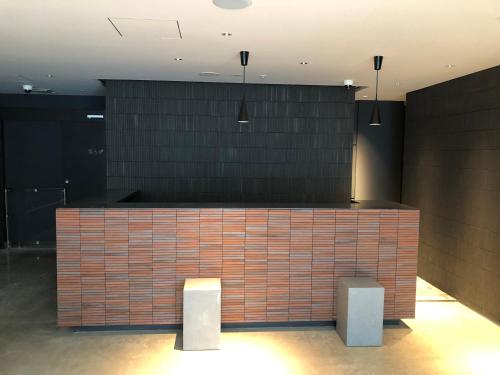 a lobby with a brick counter with two stools at LOF HOTEL Shimbashi in Tokyo