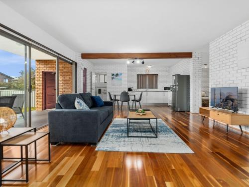 a living room with a couch and a table at Ammos by Experience Jervis Bay in Vincentia