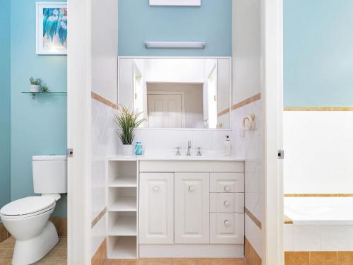 a bathroom with a white sink and a mirror at The Sanctuary at Greenfield Beach by Experience Jervis Bay in Vincentia