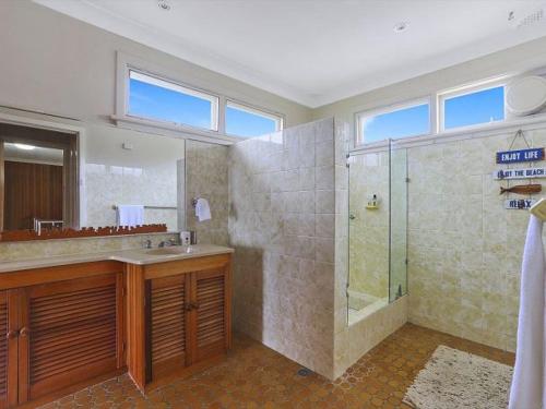 ein großes Bad mit einer Dusche und einem Waschbecken in der Unterkunft Summer Breeze by Experience Jervis Bay in Vincentia