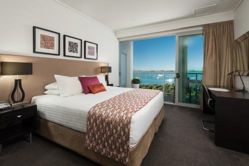 a hotel room with a bed and a view of the ocean at Hotel on Devonport in Tauranga