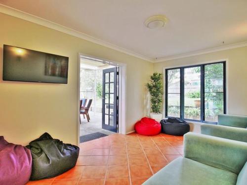 a living room with a couch and a tv at Benjos by Experience Jervis Bay in Vincentia