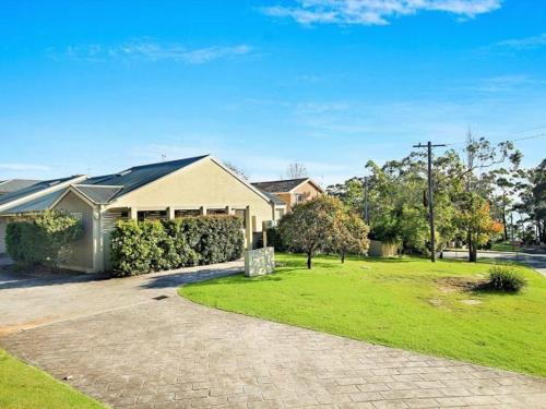 a house with a driveway in front of a yard at Saltbush at Vincentia by Experience Jervis Bay in Vincentia