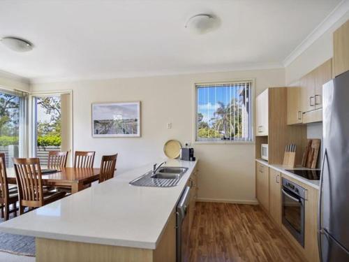 a kitchen and dining room with a table and chairs at Saltbush at Vincentia by Experience Jervis Bay in Vincentia