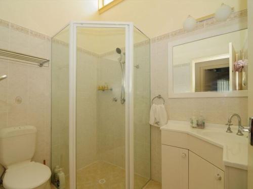 a bathroom with a shower and a toilet and a sink at Seaview by Experience Jervis Bay in Vincentia