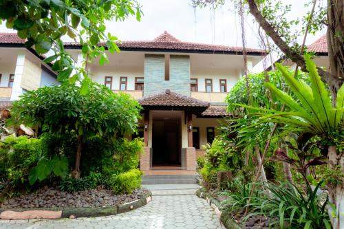 a house with a pathway leading to the front door at Hotel Mahkota Plengkung by ecommerceloka in Banyuwangi
