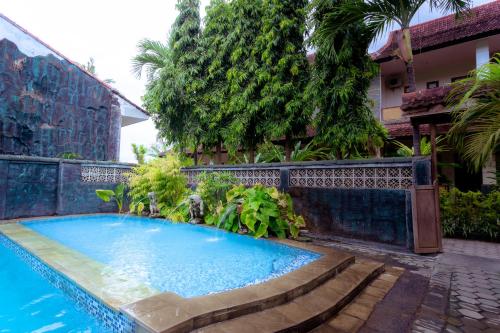 a swimming pool in front of a house at Hotel Mahkota Plengkung by ecommerceloka in Banyuwangi