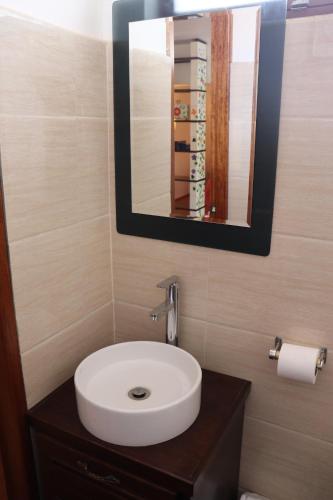 a bathroom with a white sink and a mirror at Casa Rafaela in Cusco