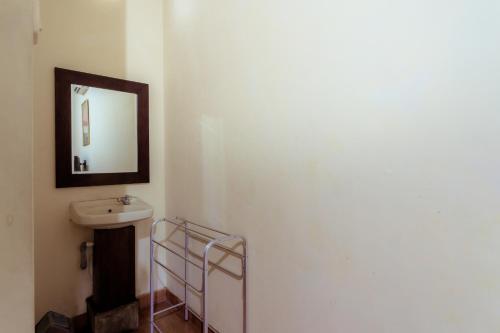a bathroom with a sink and a mirror on the wall at Hotel Mahkota Plengkung by ecommerceloka in Banyuwangi