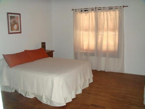 a bedroom with a white bed and a window at Vista del Condor in Villa Ciudad de America