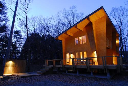 una pequeña cabaña de madera en el bosque por la noche en Logcabin Miyagawa in Nasu -那須 宮川邸-, en Nasu