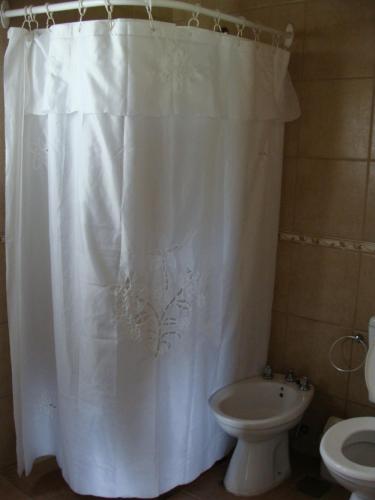 a bathroom with a white shower curtain and a toilet at Vista del Condor in Villa Ciudad de America