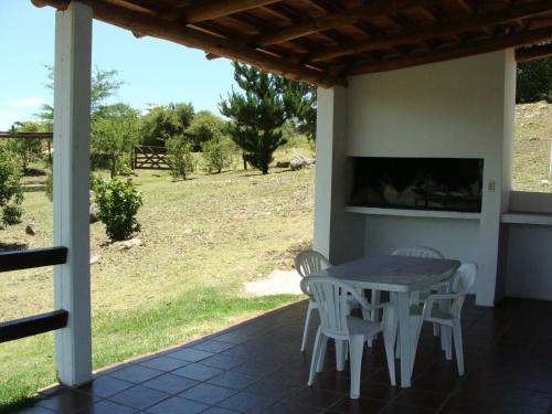 a table and chairs on a patio with a view of a field at Vista del Condor in Villa Ciudad de America