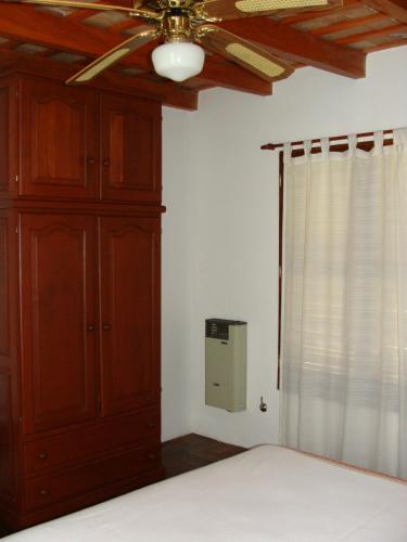 a bedroom with a ceiling fan and a cabinet at Vista del Condor in Villa Ciudad de America