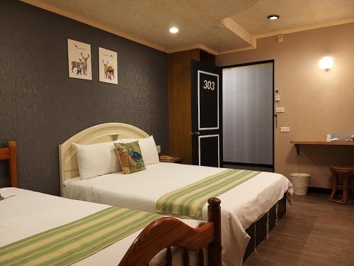 a hotel room with two beds and a window at Guan Lun Hotel in Hualien City