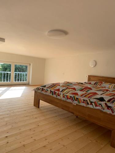 Schlafzimmer mit einem Bett und Holzboden in der Unterkunft Appartment am Königsberg, Lössau in Schleiz