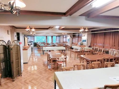 a restaurant with tables and chairs in a room at Villa Alpen in Yamanouchi