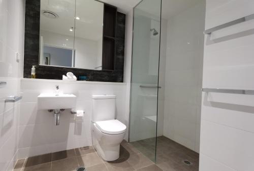 a bathroom with a toilet and a sink and a shower at KOZYGURU Chatswood Luxury Studio Walk to Chatswood Chase NCH088-721 in Sydney
