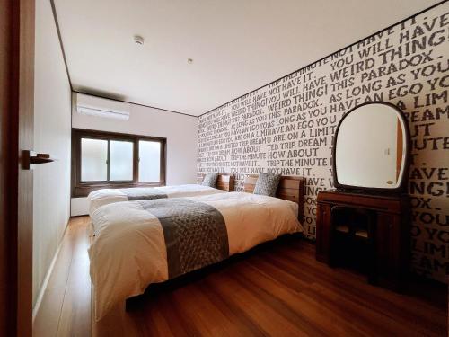 a bedroom with a large bed and a mirror at 和美庵 有7个卧室和宽敞的餐厅客厅 整栋出租 可住18人 国分寺旁 距车站 朝市 古街等景区步行6分钟 in Takayama