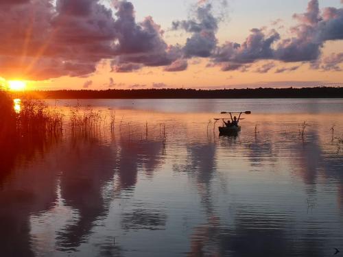 a boat floating on a lake at sunset at Sea2 in Nowęcin