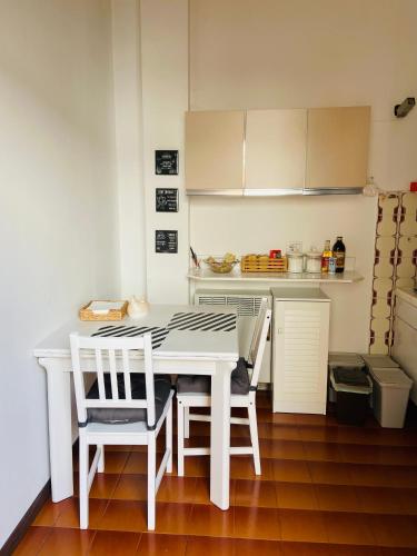a white kitchen with a white table and chairs at La Betulla in Rivanazzano