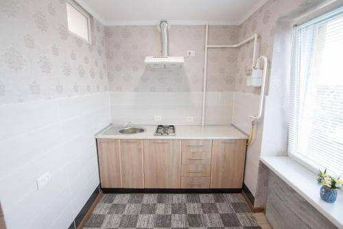 a small bathroom with a sink and a window at Уютная однокомнатная квартира возле басейнов in Berehove
