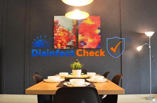 a dining room table with ahibited check sign on the wall at Desaru Cosy Homestay - near WaterPark, Beach, Rapid -Wifi, TVbox, Steamboat, BBQ Available in Desaru