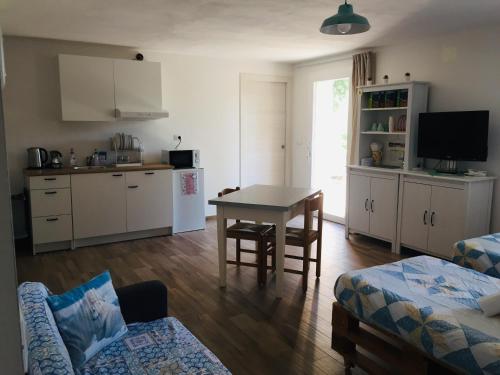 a living room with a table and a kitchen at B&B I Falchi Pellegrini in Monzuno