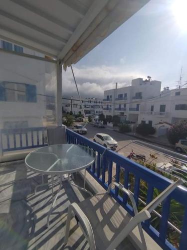 a table and chairs on a balcony with a view of a street at Xristiana's House in Tinos Town