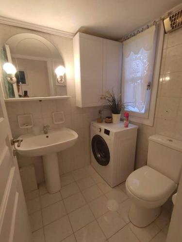 a bathroom with a sink and a toilet and a mirror at Xristiana's House in Tinos Town