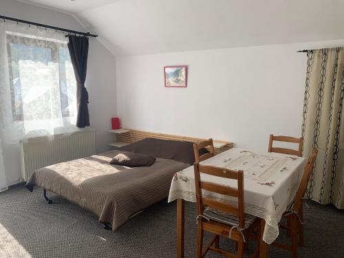 a bedroom with a bed and a table and chairs at Hygge House in Buşteni