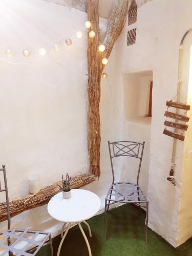 Cette chambre comprend une table blanche et une chaise. dans l'établissement Studio Montpellier écusson, à Montpellier
