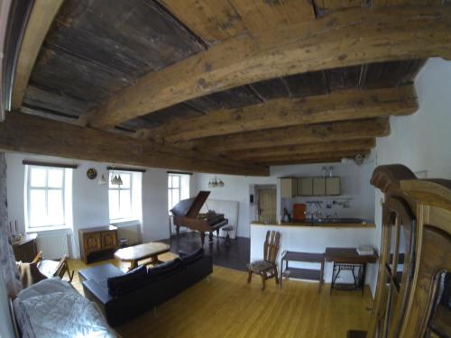 un soggiorno con soffitti in legno e pianoforte di Statek Křinice a Křinice