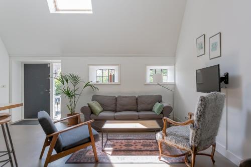 a living room with a couch and a tv at Aldehoeve-logies in Workum