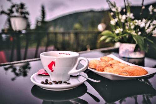 a cup of coffee and a plate of pastries on a table at Pensiunea Adriana Straja in Straja