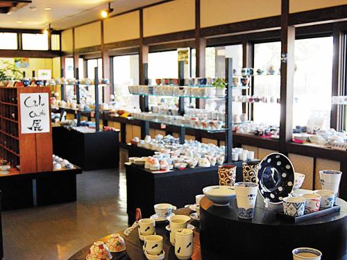 a store filled with plates and bowls on tables at Ooedo Onsen Monogatari Ureshinokan in Ureshino