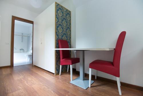 Habitación con mesa y 2 sillas rojas en Casa Dolce, en Venecia