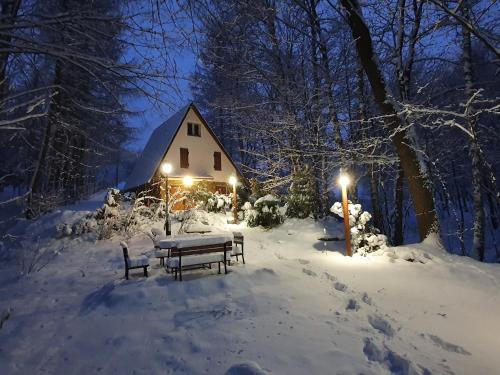 a picnic table in the snow in front of a cabin at Leśny Zakątek in Dębica