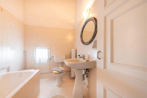 a bathroom with a sink and a toilet and a mirror at Archontiko Petrettini Boutique Hotel in Corfu Town