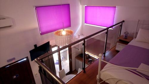a room with two purple windows and a staircase at Levantes in Asprovalta