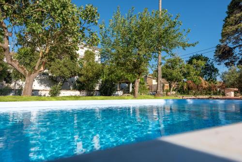 une piscine d'eau bleue et d'arbres dans l'établissement Archontiko Petrettini Boutique Hotel, à Corfou
