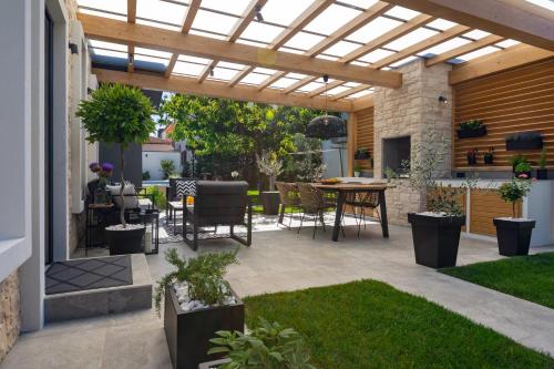 a patio with a pergola and a table and chairs at Villa Villetta in Novigrad Istria