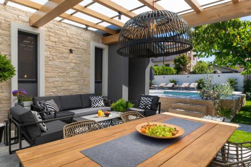a patio with a table with a bowl of fruit on it at Villa Villetta in Novigrad Istria