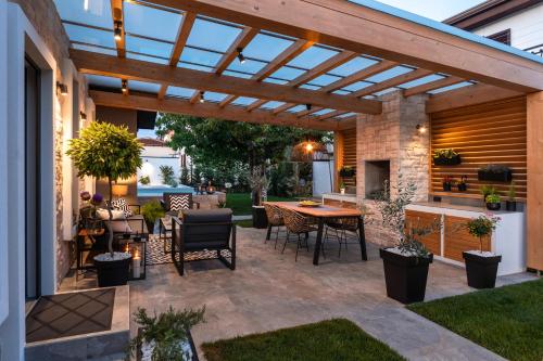 a patio with a wooden pergola with a table and chairs at Villa Villetta in Novigrad Istria