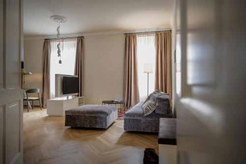 a living room with a couch and a television at Hotel Bruneck Design-Suites in Brunico